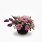 Bouquet of pink roses and purple tulips in a black pot on a white background
