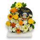 Floral arrangement with 'Eid al Adha mubarak' card featuring a sheep and crescent moon on a white background.