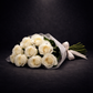Bouquet of white roses with a white ribbon on a black background