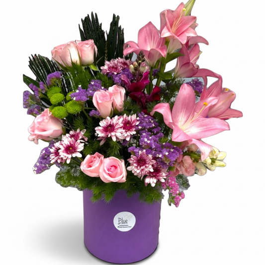 Bouquet of pink and purple flowers in a purple container on a white background