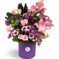 Bouquet of pink and purple flowers in a purple container on a white background